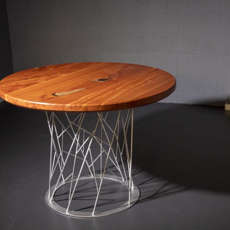 Round wood dining table on a steel rod base