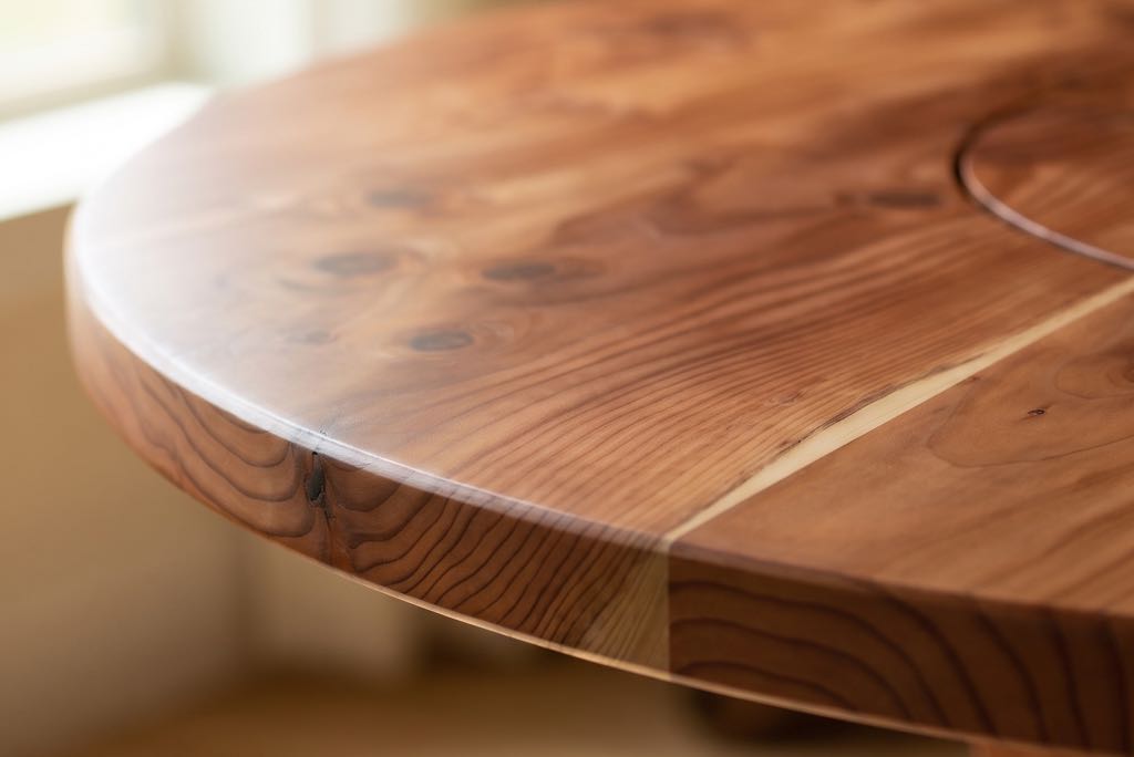 The softly eased edge of the redwood top, with a sapwood stripe running out to it