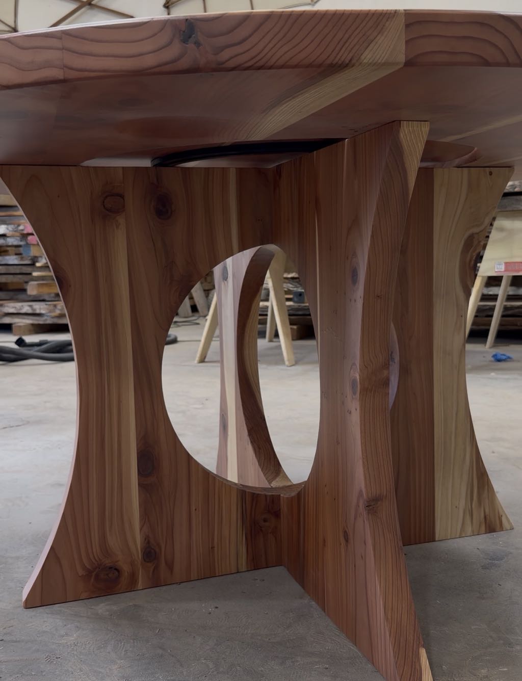 The cross base under the redwood top, two panels with circular cutouts