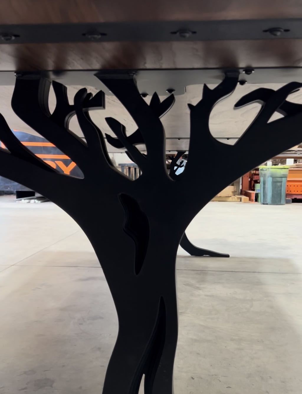 Close up of the steel branches of a leg under the walnut top