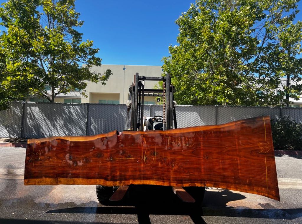 A long redwood slab on the forklift in our yard