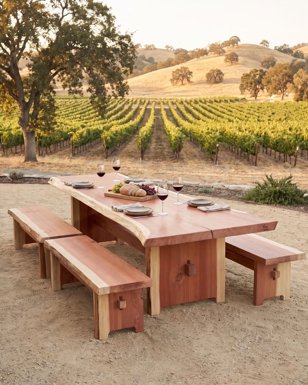 Redwood trestle table with benches set outdoors among vineyard rows