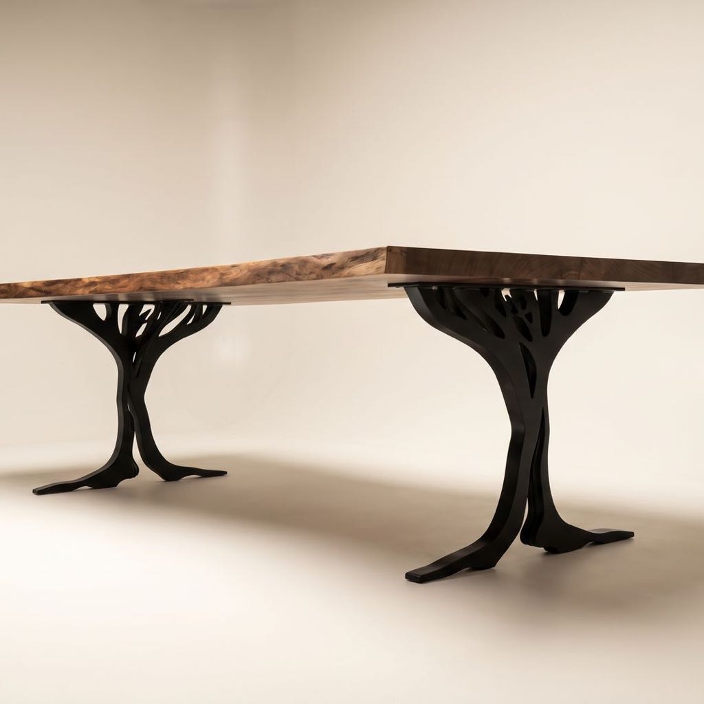 Claro walnut tree-leg table on a cream studio backdrop