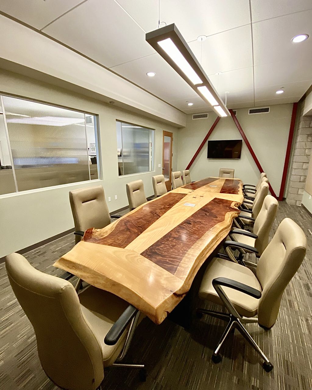 The real ash and redwood conference table in the conference room at 19six Architects, with chairs down both sides