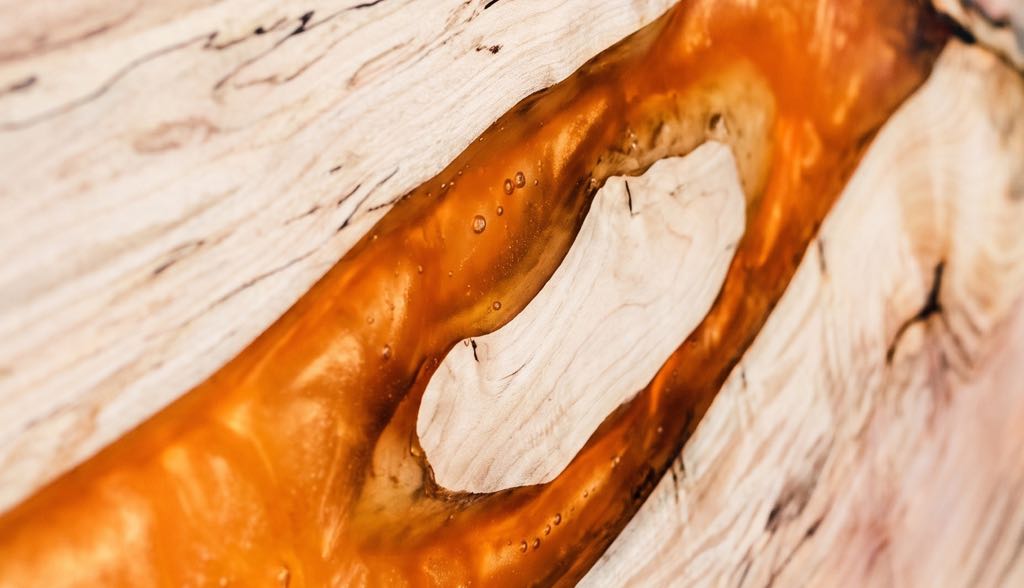 Close-up of the orange resin river and the pale island of sycamore inside it