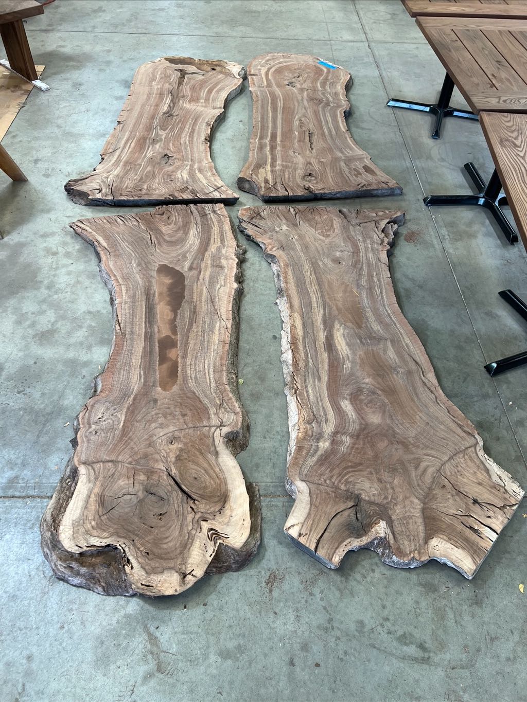 The four walnut slabs from the orchard tree laid out on the shop floor in two bookmatched pairs, before they were built into the table